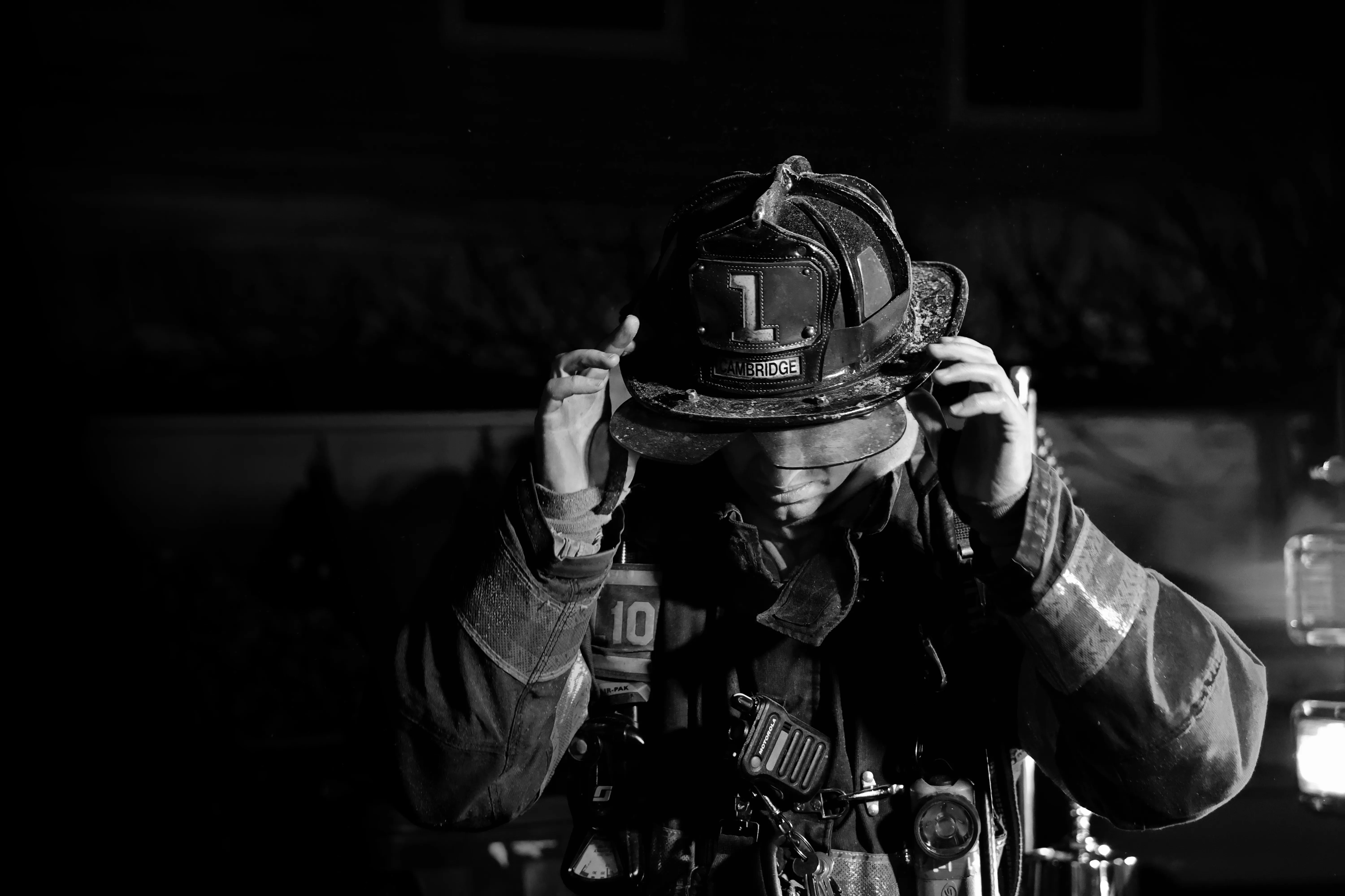 Firefighter adjusting leather fire helmet showcasing custom firefighter business website