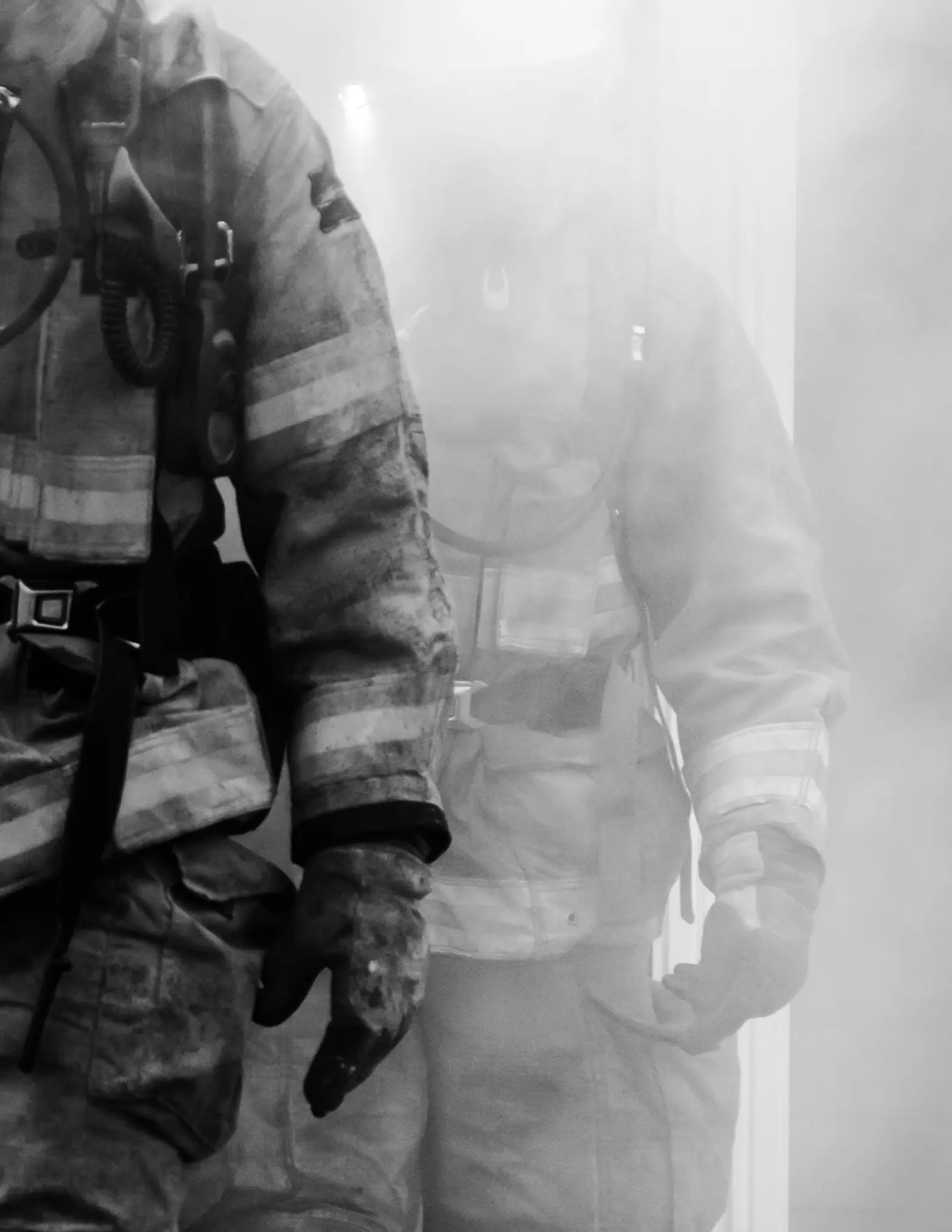 Firefighters walking through smoke.