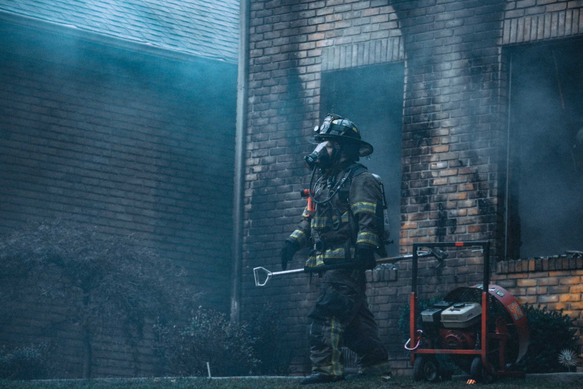 Firefighter walking out of a burning building